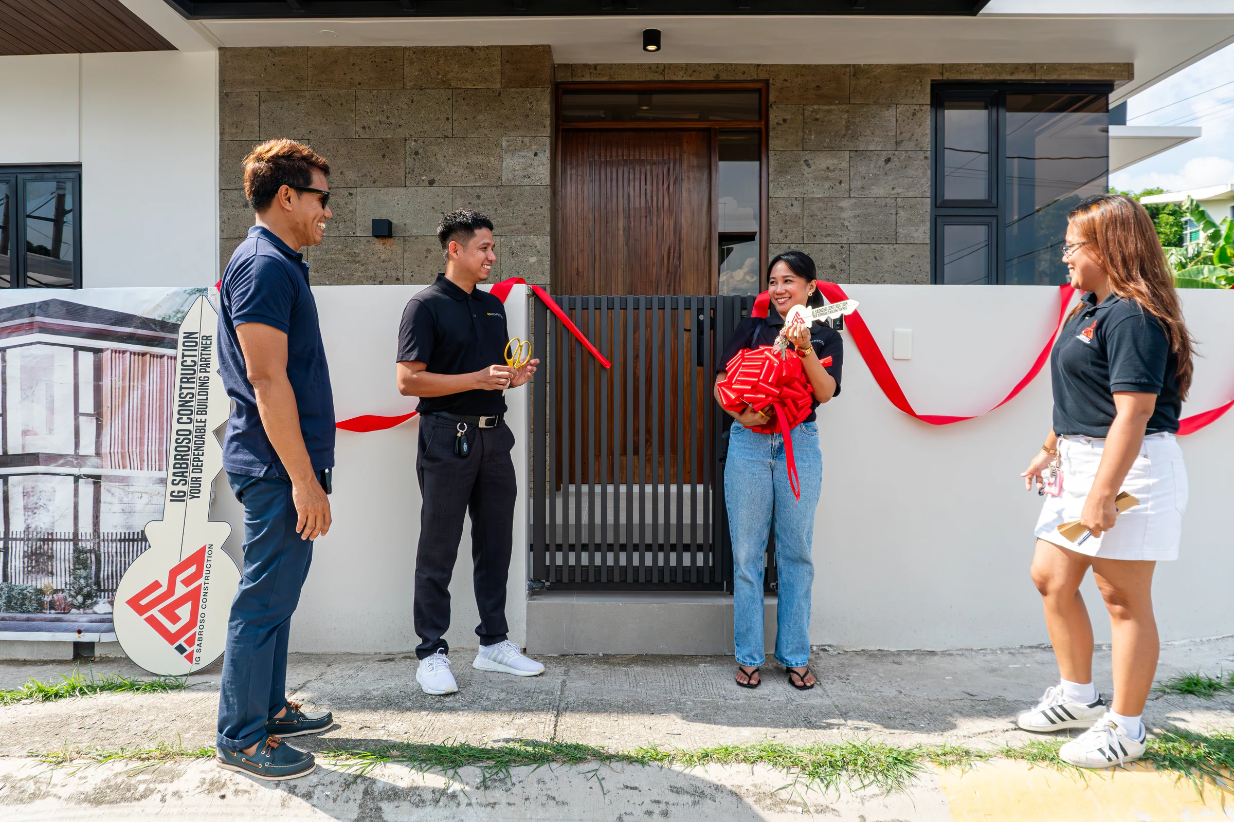 IG Sabroso team presenting a ceremonial project key during a completed residential handover